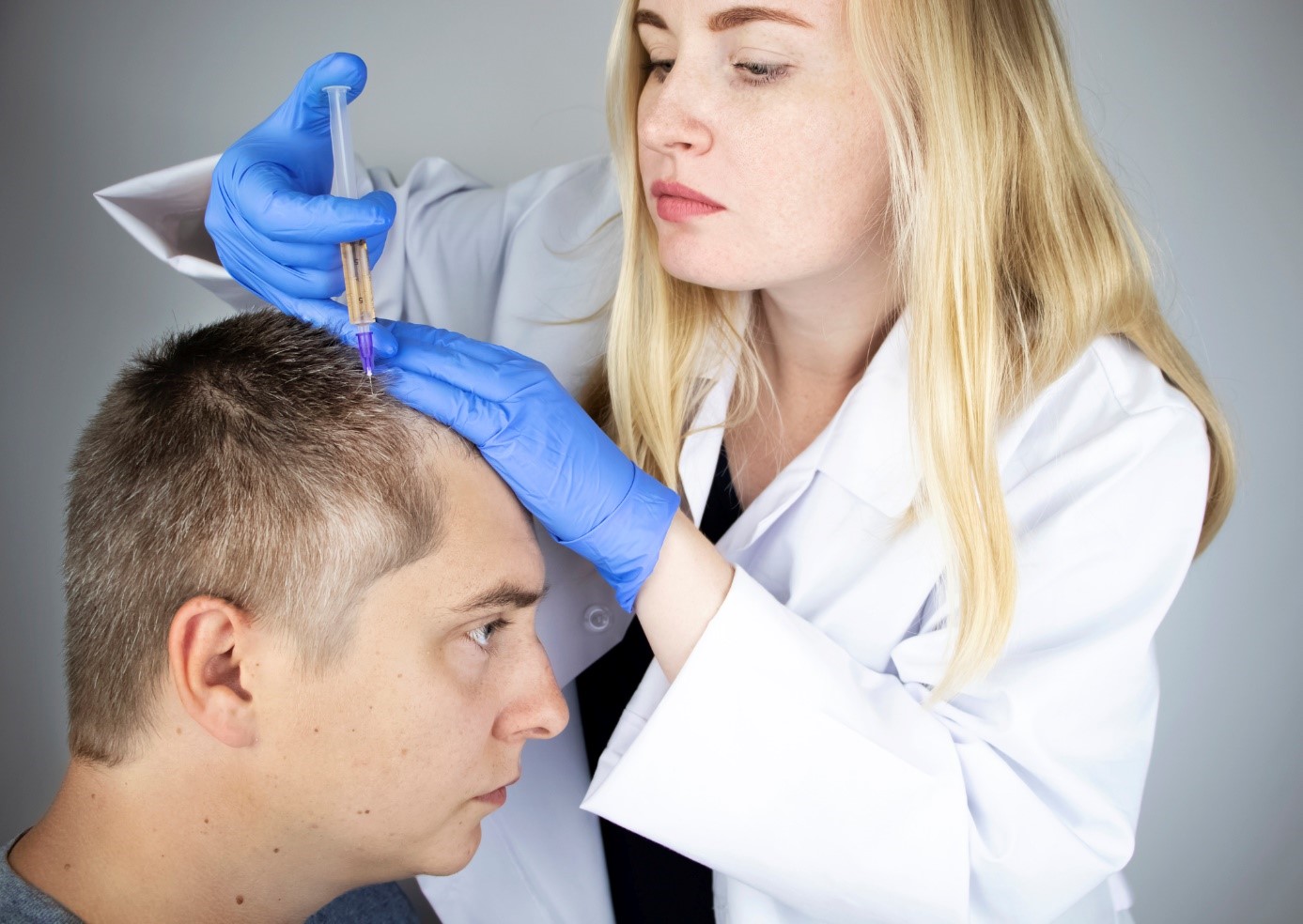O diagnóstico e a subsequente escolha da forma correcta de tratamento são importantes: Getty Images Tratamento da queda de cabelo, um médico injecta um medicamento na cabeça de um senhor, um doente