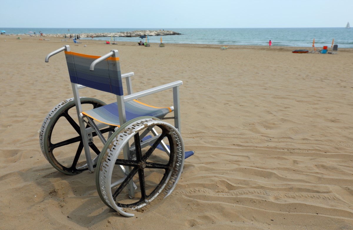 Os doentes perdem gradualmente a capacidade de cuidar de si próprios. Fonte da fotografia: Getty Images Cadeira de rodas vazia na praia