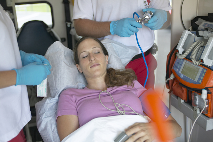 Diagnóstico e assistência profissional. Exame e controlo dos sinais vitais. Origem da fotografia: Getty Images Doente na ambulância e paramédicos