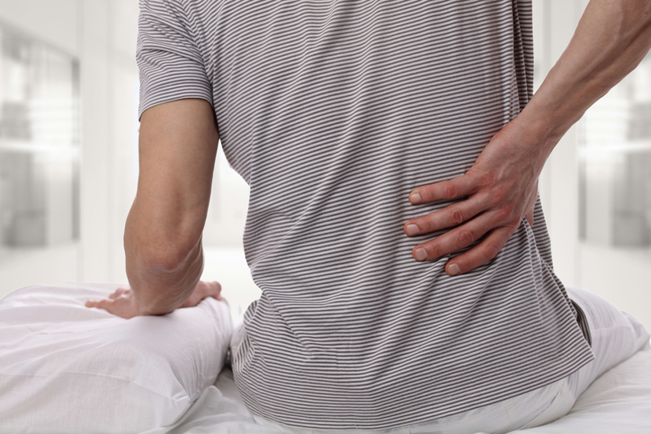 Dores de cabeça e rigidez da coluna vertebral. Fonte da foto: Getty Images Bechterev - um jovem sofre de dores matinais e de rigidez da coluna vertebral