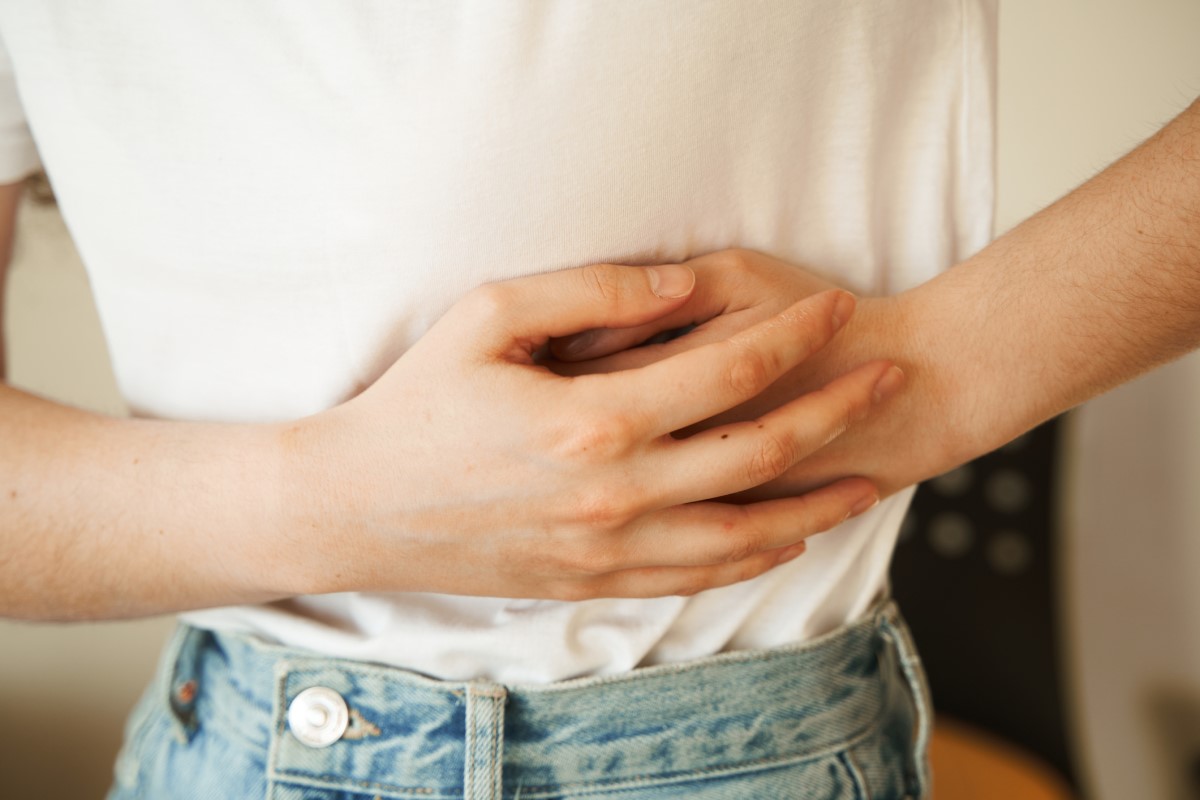 Os primeiros sintomas da obstrução intestinal estão relacionados com o aparelho digestivo: surgem vómitos, dores intensas, prisão de ventre, cessação da saída de gases e abdómen distendido: Getty Images A mulher segura o lado dorido com as mãos, tem dores abdominais e outros problemas de saúde que podem indicar obstrução intestinal.