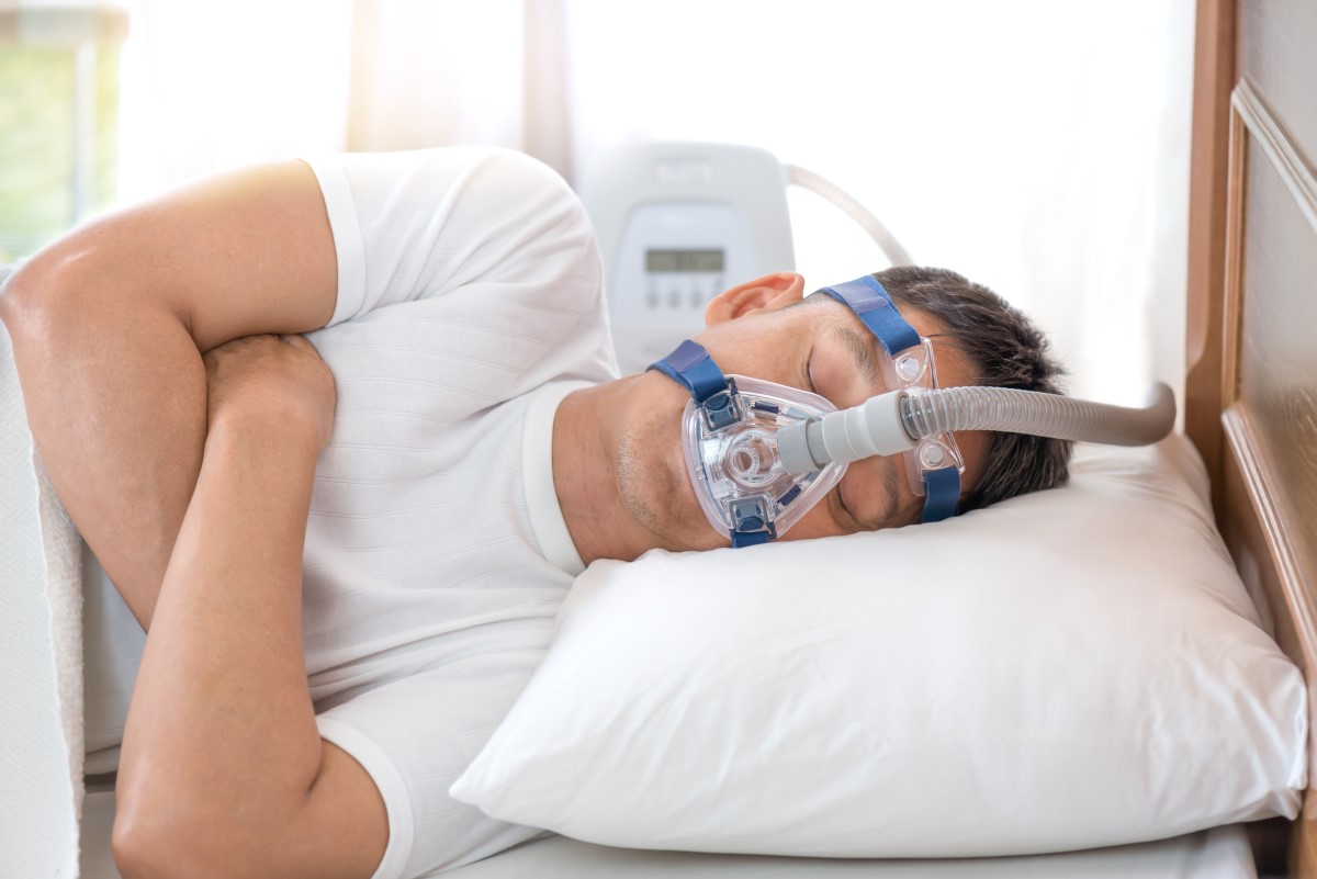 Máscara CPAC para manutenção da pressão durante o sono: Getty Images Máscara CPAP no rosto de um homem com apneia do sono