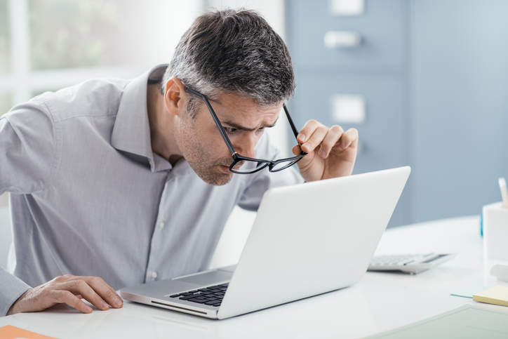 Ler e localizar objectos próximos é problemático. Foto: Thinkstock O problema é a leitura - o homem por detrás do computador não consegue ver bem sem óculos
