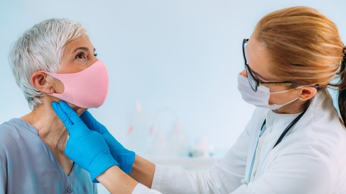 Um dos sintomas também pode ser uma glândula aumentada (palpável ou visível): Getty Images O médico examina a glândula tiroide de uma mulher idosa por palpação - bócio, uma glândula aumentada como sintoma de tirotoxicose.