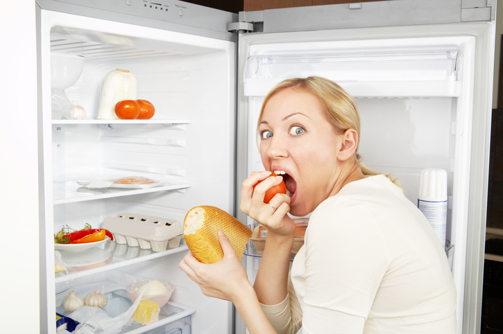Um bulímico sofre de um desejo compulsivo por comida: Getty Images Mulher no frigorífico como sinal de excesso de comida na bulimia