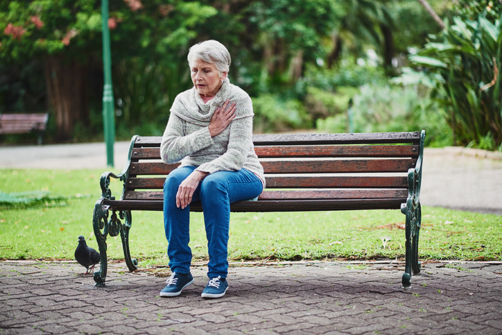 O stress provoca dificuldades - pelo contrário, estas diminuem com o repouso. No entanto, isto não se aplica num curso severo. Foto: Getty Images Uma mulher idosa está sentada num banco, com problemas cardíacos.