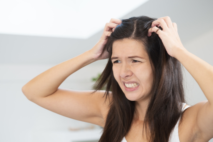 A comichão na pele é um sintoma comum que acompanha a doença: Getty Images Uma mulher tem um problema de cabelo, caspa, comichão no couro cabeludo, coça a cabeça com as mãos