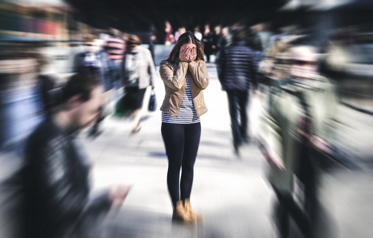 Pode ocorrer hipersensibilidade ao ruído e à luz: Getty Images Mulher confusa no meio de uma multidão de pessoas, tem um problema mental, sensibilidade exagerada à luz e aos sons, ruído