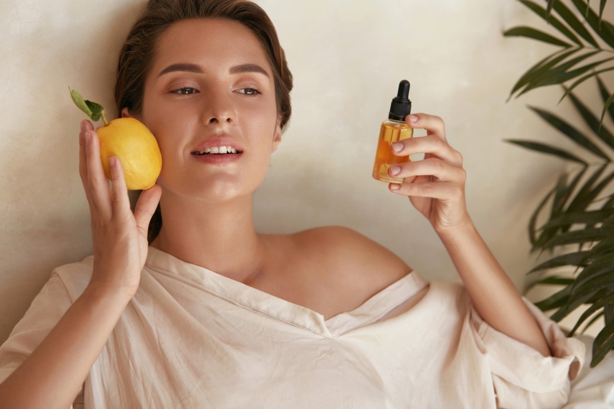 A vitamina C também ajuda nos problemas de pele e beneficia a pele: Getty Images Mulher com um limão e um frasco de extrato de vitamina C na mão, uma vitamina que ajuda a pele