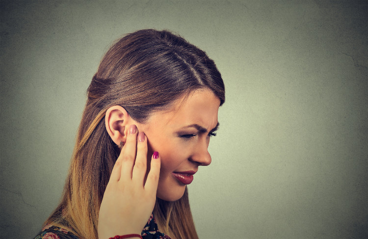 Doenças do sistema auditivo Fonte: Getty Images mulher a segurar a orelha com a mão