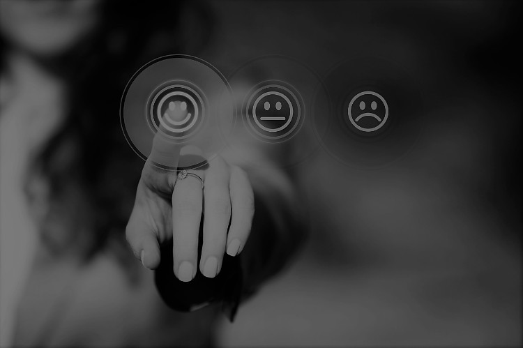 O importante é fazer a escolha certa. Fonte: thinkstock photos uma mulher a carregar com o dedo no botão de um smiley risonho de uma seleção de três smileys