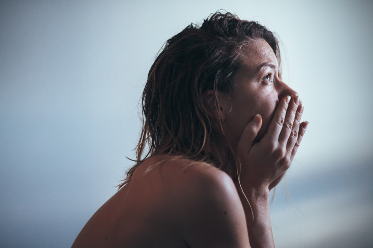 A depressão desencadeia pensamentos compulsivos: Getty Images mulher triste de perfil a olhar para cima, com as mãos a tapar a boca