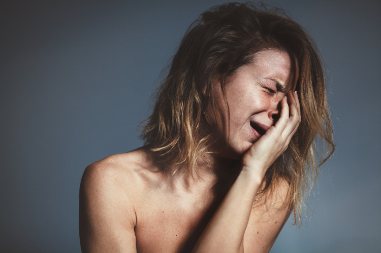 Os ataques de ansiedade e de choro são comuns: Getty Images uma mulher num ataque de choro segura a cara com a mão