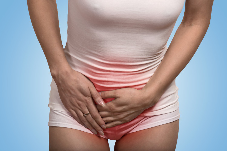 As doenças pós-renais mais comuns são a cistite: Getty Images mulher a segurar a zona inferior do abdómen por causa da dor