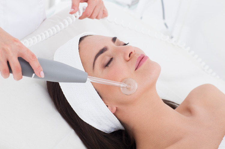 A limpeza natural da pele tem por vezes melhores efeitos: Getty Images uma mulher com uma fita branca na cabeça está a ser limpa com uma máquina