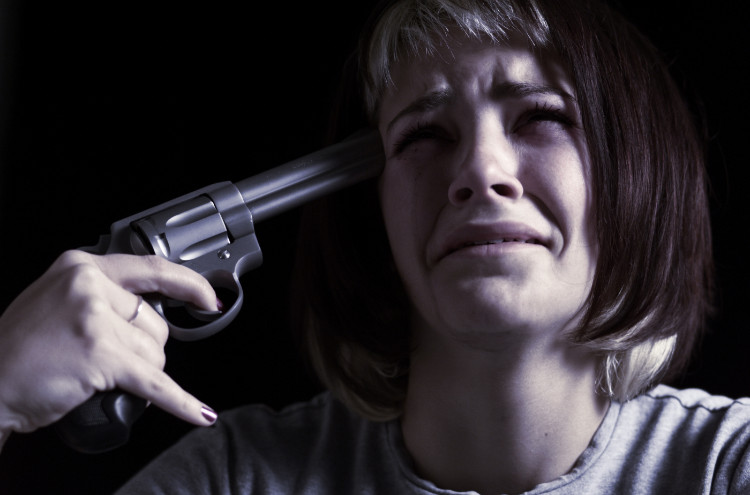 A depressão é uma causa comum de suicídio: Getty Images uma mulher a chorar tem uma arma apontada à cabeça