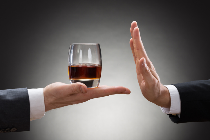 As bebidas alcoólicas são a principal causa de úlceras gástricas e, em úlceras gástricas já estabelecidas, aceleram a rutura da úlcera e a hemorragia: Getty Images a mão de uma pessoa está a segurar um copo de álcool e a mão de outra pessoa está a rejeitá-lo