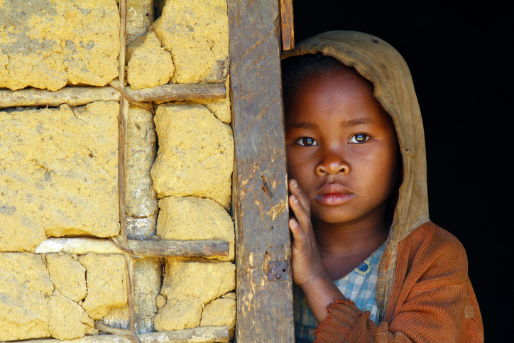 As zonas de maior risco são as zonas pobres com baixos padrões de saneamento. Fonte: Thinkstock Uma criança negra pobre com um olhar triste no rosto, de capuz, encostada à parede