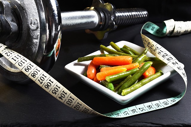 A modificação da dieta juntamente com a atividade física é a coisa mais importante na perda de peso. Fonte: Thinkstock Um haltere cromado colocado ao lado de um prato quadrado. No prato está um legume e ao lado dele uma fita métrica de alfaiate.
