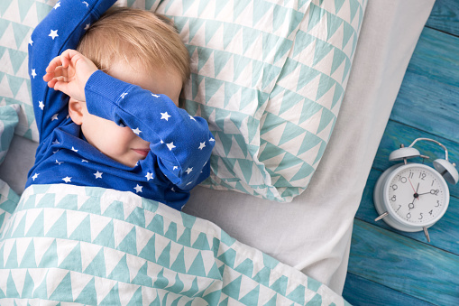 Idade pré-escolar Foto: Getty Images Acordar um rapazinho de pijama azul, junto ao despertador