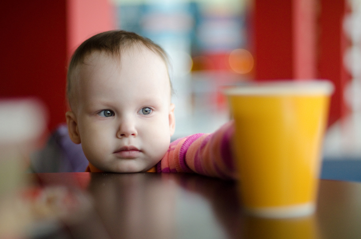 Distinguir entre bebidas apropriadas e inapropriadas Foto de origem: Getty Images Uma criança pequena pega num copo de água que está em cima da mesa