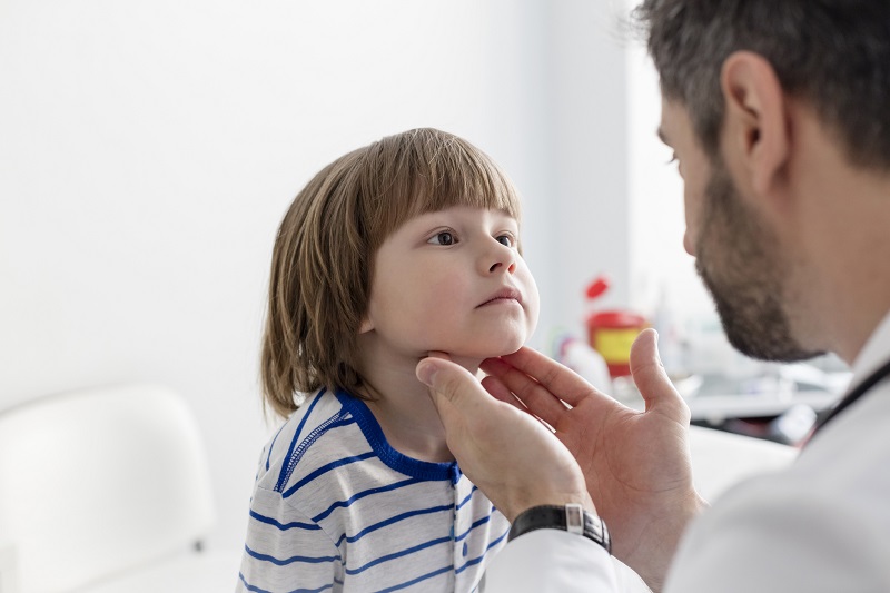 Exame médico das amígdalas de uma criança por palpação Fonte: Getty Images Exame médico das amígdalas numa criança