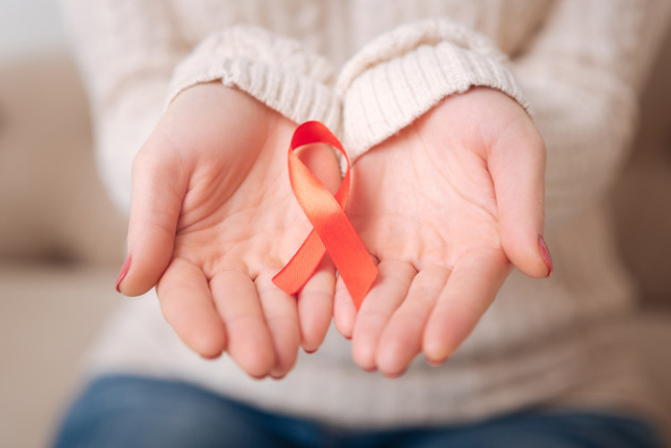 O laço vermelho como símbolo da luta contra a SIDA. Fonte: Getty Images fita vermelha nas mãos da mulher