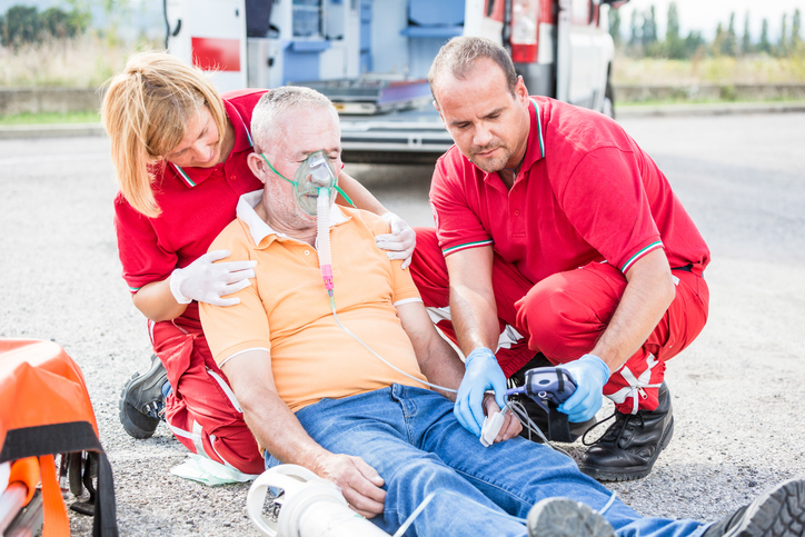 Um doente com enfarte do miocárdio tem de ser levado para uma unidade especializada o mais rapidamente possível. Foto: Thinkstock paramédicos junto a um doente desmaiado