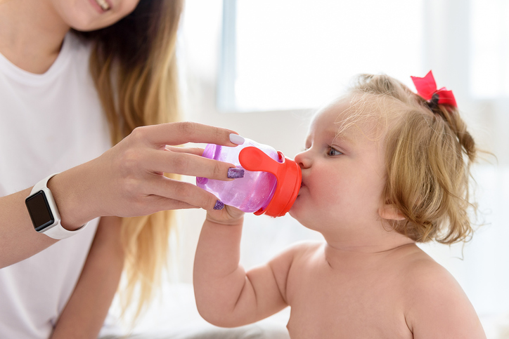 As crianças pequenas devem ser encorajadas a beber por um dos pais. Fonte da fotografia Getty Images Mãe dá água limpa para a menina beber