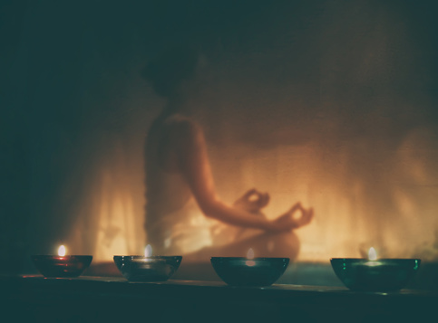 A auto-hipnose e a meditação são utilizadas por um número cada vez maior de pessoas: Getty Images mulher a meditar à luz de velas