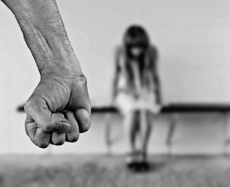 As perturbações comportamentais e a violência doméstica são comuns: Getty Images punho masculino, violência, rapariga tímida sentada ao fundo
