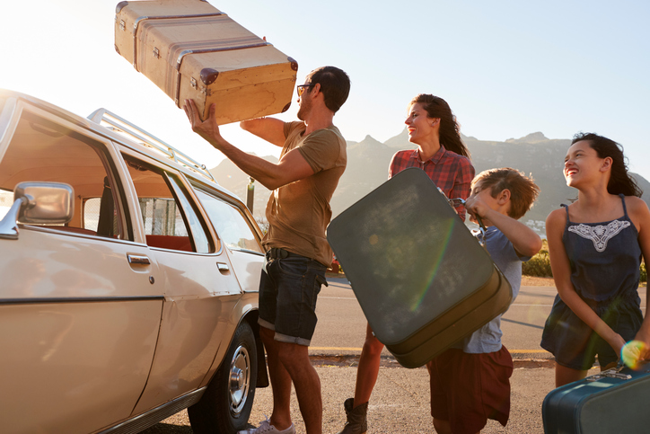 As férias são um período de descontração, mas também podem estar cheias de armadilhas e situações inesperadas. Fonte: Thinkstock família a fazer as malas no carro antes das férias