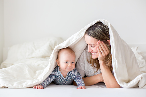 Por vezes, a presença de um adulto é importante para a satisfação e a qualidade do sono do bebé: Getty Images Criança a rir com a mãe debaixo do palanquim