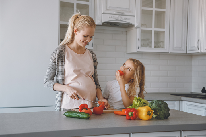 A ingestão de uma dieta equilibrada com alimentos ricos em ferro é a melhor forma de prevenção da deficiência de ferro. foto: Getty Images Mãe e filha grávidas preparam uma refeição saudável na cozinha.
