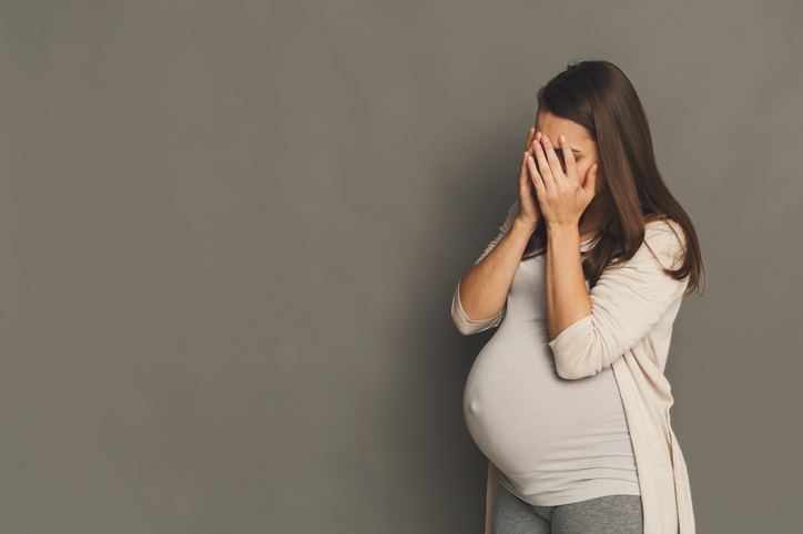 Fadiga excessiva, fraqueza ou humor deprimido podem ser sinais de anemia na gravidez. Foto: Getty Images Uma mulher grávida e cansada, cobrindo a cara com as mãos.