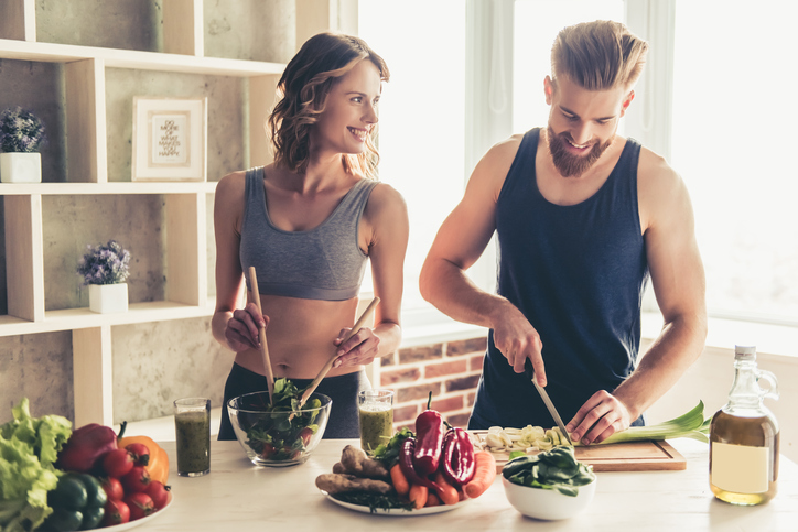 O consumidor médio deve ingerir 22,5 gramas de fibra por dia. Fonte da foto: Getty Images Um homem e uma mulher preparam uma refeição saudável na cozinha.