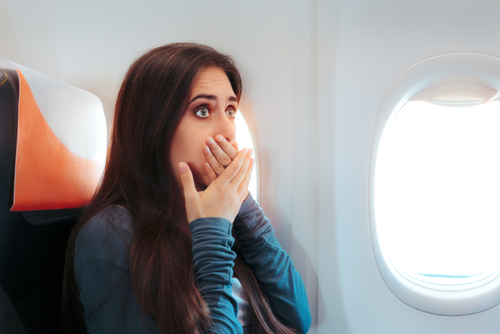 Náuseas, vómitos, azia ou dores de estômago podem surgir muito mais cedo do que o esperado. Fonte: Thinkstock uma mulher sentada à janela de um avião, tem vontade de vomitar