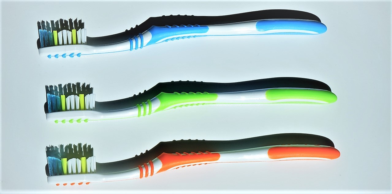 A escolha também é influenciada pela cor preferida. Fonte Getty Images Escovas de dentes, variantes de cor, três peças, azul em cima, verde no meio, cor de laranja em baixo, cerdas coloridas na cabeça da escova de dentes, azul, verde e branco