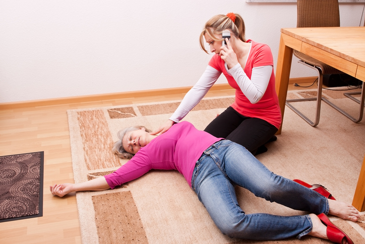 Em caso de perda de consciência, pedir ajuda. Foto. Getty Images Uma mulher está deitada no chão, inconsciente, e a outra mulher está a pedir ajuda.