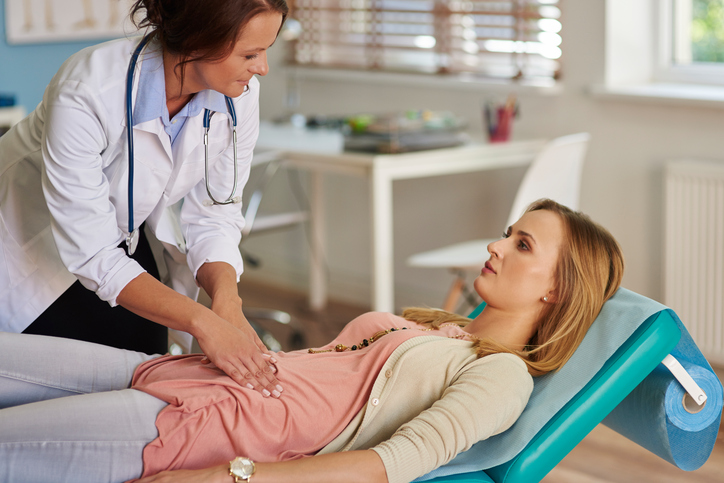 A dor persistente no abdómen inferior requer um exame profissional: Getty Images Um médico examina uma mulher com dores abdominais