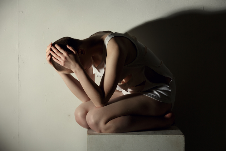 Os estados de euforia alternam com a depressão. foto de origem: Getty Images Mulher ajoelhada, deprimida, mãos na cabeça