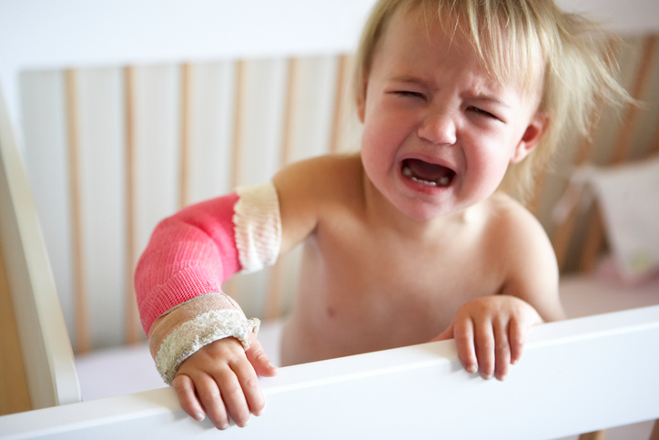 Uma causa comum de dor é uma lesão: Getty Images A criança está a chorar, tem dores no membro superior, para uma fratura do antebraço, o membro superior está engessado, numa tala