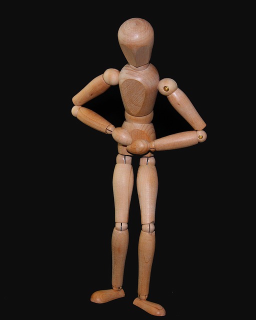 a figura de madeira está a segurar a barriga, indicando dor abdominal