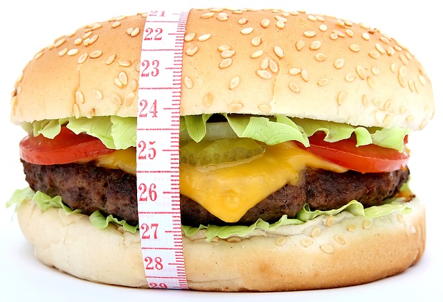 A qualidade da dieta, a ingestão de energia e o gasto de energia são decisivos. foto de origem: Getty Images Hambúrguer e uma fita métrica de alfaiate à volta