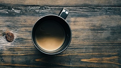 O café mancha de escuro. Fonte: Getty Images café numa chávena sobre a mesa, vista de cima