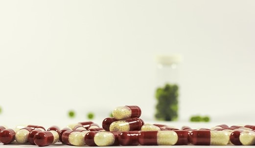Drogas espalhadas livremente, de cor vermelha e branca e drogas verdes no fundo de uma garrafa