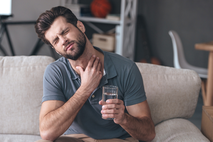 Até o simples facto de beber água pode piorar uma dor de garganta: Getty Images Homem com dores de garganta - agravadas pelo consumo de água