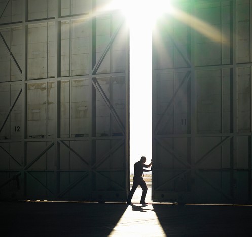 Quando se passa de um ambiente escuro para um ambiente de luz brilhante. Fonte da foto: Getty Images Um homem sai do corredor escuro para a luz forte, o sol está a brilhar, abre uma porta no corredor