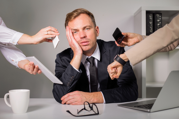 O homem está exausto, sobrecarregado de trabalho.