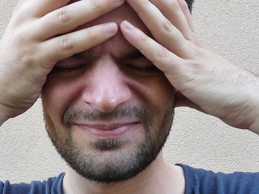 A pressão nos olhos acompanha frequentemente a dor de cabeça e a enxaqueca. Fonte da foto: Getty Images O homem está a segurar a cabeça, está a ter uma enxaqueca